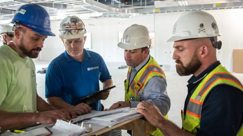 John Concannon and three others discussing blueprints