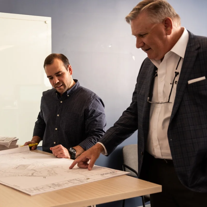 Jay Darcey and employee discussing blueprint