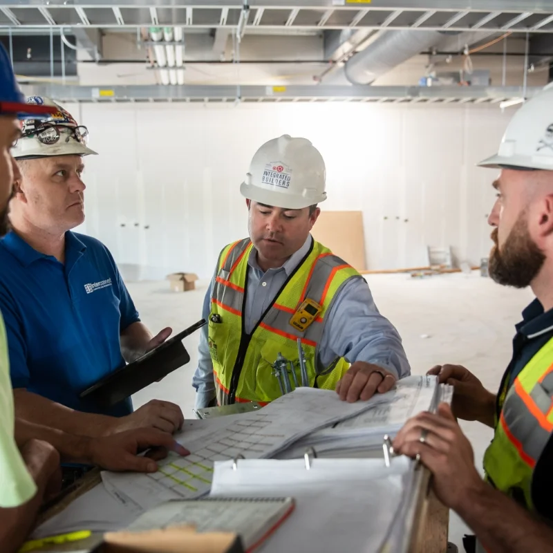 Integrated Builders workers reviewing documents at worksite