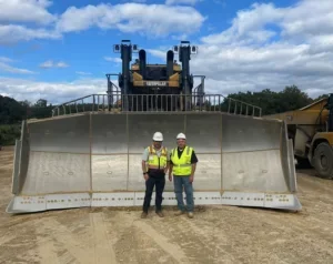 two men standing in front of bulldozer