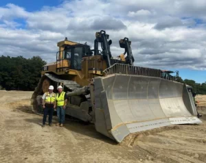 two men standing in front of bulldozer