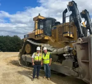 two men standing in front of bulldozer
